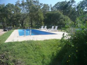 a swimming pool with lounge chairs in a park at Cabañas Wencesmar in Hipólito Yrigoyen