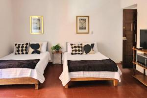 two beds in a room with a tv at Cómoda Habitación con Baño en Pasillo in Querétaro