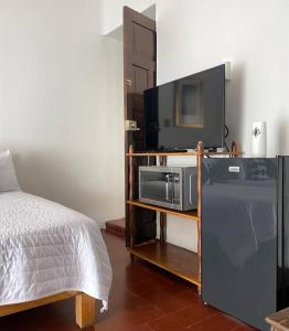 een slaapkamer met een bed en een televisie op een plank bij Cómoda Habitación con Baño en Pasillo in Querétaro