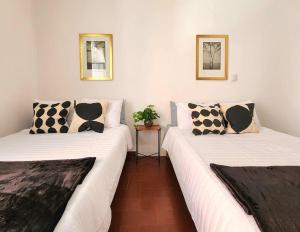 two beds with black and white pillows in a room at Cómoda Habitación con Baño en Pasillo in Querétaro