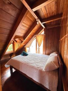 a bed in a room in a wooden house at TONYs HOUSE MINDO in Mindo