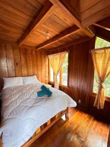 1 dormitorio con 1 cama en una habitación de madera en TONYs HOUSE MINDO, en Mindo