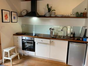 a kitchen with a sink and a stove at Crabapple Cabin in Bowral +5 photos