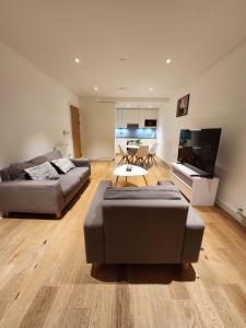 a living room with two couches and a flat screen tv at The maud luxury garden in London