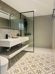 a bathroom with a sink and a mirror and a toilet at Attitude Resort Langkawi in Pantai Cenang