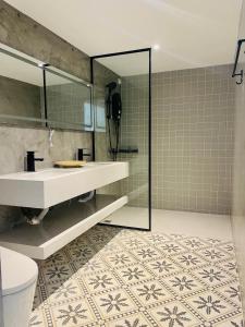 a bathroom with a sink and a mirror and a toilet at Attitude Resort Langkawi in Pantai Cenang +21 photos