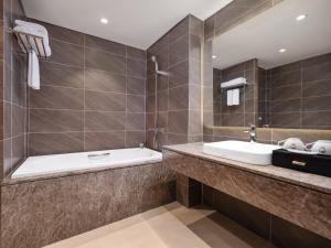 河內的住宿－Nesta Hotel & Spa，浴室配有盥洗盆和浴缸。