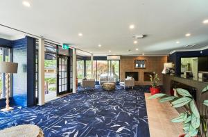 a living room with a blue carpet at Leura Gardens Resort in Leura +69 photos
