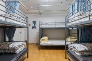 two bunk beds in a room with wooden floors at Good Stay Itaewon in Seoul
