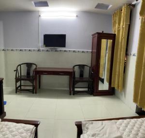 a room with a table and two chairs and a television at Phúc Lộc Thọ Hotel in Ho Chi Minh City