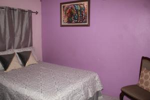 a bedroom with a bed and a picture on the wall at Elegant & Stylish 2BR New Kingston in Kingston