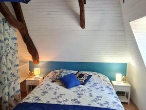 a bedroom with a bed with blue sheets and two lamps at Gîte Cendrieux, 4 pièces, 6 personnes - FR-1-616-68 in Cendrieux