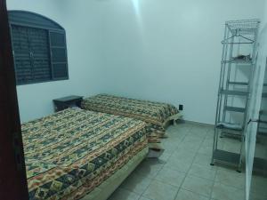 Un dormitorio con 2 camas y una escalera. en Chacara Recanto Paraíso Guacuri 2 en Itupeva