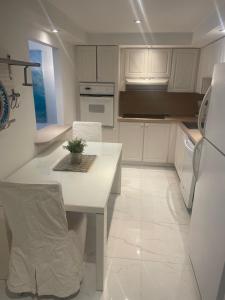 a kitchen with white cabinets and a table and a refrigerator at Ocean Reserve STR-01045 in Miami Beach