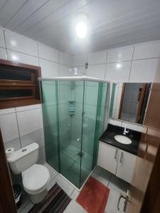 a bathroom with a glass shower and a toilet at Residencial Silveira in Itajaí