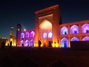 a building lit up at night with purple lights at Guest House Orzu in Khiva