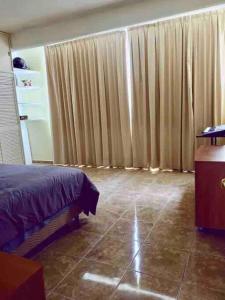 Cozy apartment to stay - 2bedrooms for 4 guests! في Asunción Nochixtlán: غرفة نوم مع ستائر وسرير وأرضية من البلاط