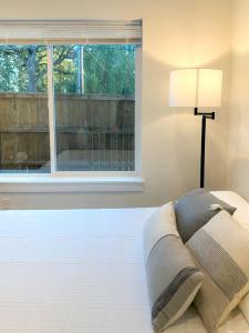 uma cama branca com um candeeiro e uma janela em New Comfort Cozy Modern Apartment Unit4 em Vancouver