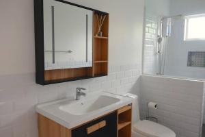 ein Badezimmer mit einem Waschbecken, einem WC und einem Spiegel in der Unterkunft Brand New Home in Cebu City with 3 Large Bedrooms! in Cebu City