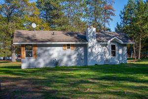 a small blue house on a grass field at Relaxing Lakeside Retreat in Rhinelander