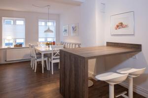 Il comprend une cuisine et une salle à manger avec une table et des chaises en bois. dans l'établissement Stadthaus Flensburg, à Flensbourg