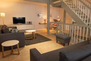 a living room with a couch and a tv at Stadthaus Flensburg in Flensburg