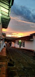 a view of a building with the sunset in the background at Casa Orquidea Hostal Barichara in Barichara
