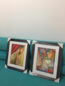 two framed pictures of a woman and a man at un nouveau appartement avec un parking gratuit sur place in La Marsa