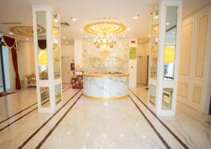 vestíbulo con lámpara de araña y encimera de mármol en Dezon Hotel en Quy Nhon