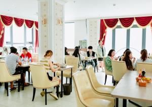 a group of people sitting at tables in a restaurant at Dezon Hotel in Quy Nhon