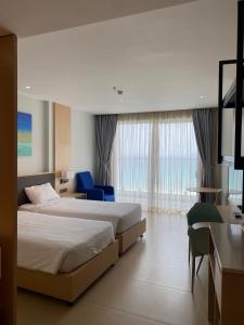 een hotelkamer met 2 bedden en een blauwe stoel bij Cam Ranh Sea View apeartment Nha Trang in Cam Ranh