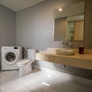 a bathroom with a toilet and a washing machine at The View Villa 2 - 2br Minimalist Villa in Uluwatu in Uluwatu