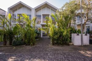 a building with a bunch of plants in front of it at The View Villa 2 - 2br Minimalist Villa in Uluwatu in Uluwatu