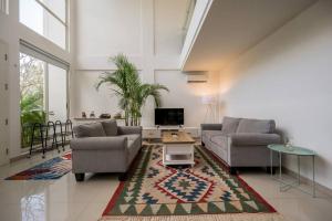 a living room with two couches and a tv at The View Villa 2 - 2br Minimalist Villa in Uluwatu in Uluwatu