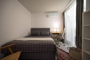 a small bedroom with a bed and a window at The View Villa 2 - 2br Minimalist Villa in Uluwatu in Uluwatu +21 photos