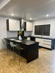 a kitchen with a black island in a room at Garden Apartments in Nadi