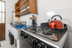 a red tea kettle sitting on top of a stove in a kitchen at Casa Leon Rinconada in Puerto Escondido