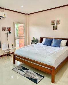 a bedroom with a large bed with blue pillows at BAAN OZONE in Hat Yai