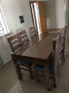 a wooden table and chairs in a room at un nouveau appartement avec un parking gratuit sur place in La Marsa