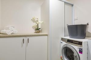 a washing machine with a basket on top of it at Ishtar Apartment 1 Luxury Living Accommodation in Huskisson