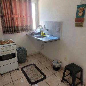 a kitchen with a sink and a stove at Excelente kitnet mobiliada pertinho mar in Vila Velha