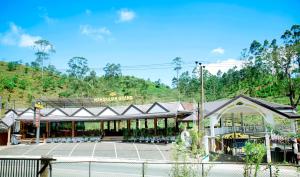 ein Gebäude mit einem Zaun vor einer Straße in der Unterkunft Maharajah Grand in Hatton