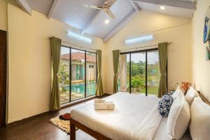 a bedroom with a bed and a large window at SaffronStays Mangi Ferra in Karjat +18 photos