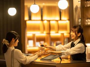 京都市にあるinsomnia KYOTO OIKEの二人の女性がレストランのテーブルで握手