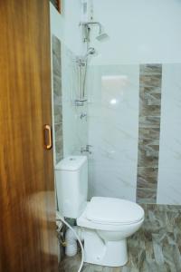 ein Badezimmer mit Toilette und Dusche in der Unterkunft Maharajah Grand in Hatton