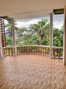 an empty house with a balcony with palm trees at BAAN OZONE in Hat Yai
