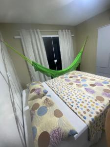 - une chambre avec un lit et un hamac vert dans l'établissement RESIDENCE HOTEL DAVI e MARIA, à Mulungu