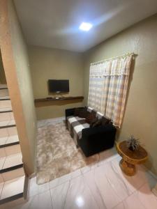 - un salon avec un canapé et une télévision dans l'établissement RESIDENCE HOTEL DAVI e MARIA, à Mulungu