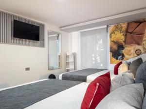 a hotel room with two beds and a flat screen tv at Hotel velero in Roldanillo +50 photos