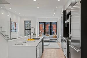 eine Küche mit weißen Arbeitsplatten und ein Wohnzimmer in der Unterkunft Logan Circle Penthouse and Rooftop Unit A in Washington